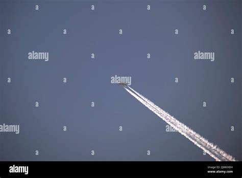 Distant Passenger Jet Plane Flying On High Altitude On Clear Blue Sky