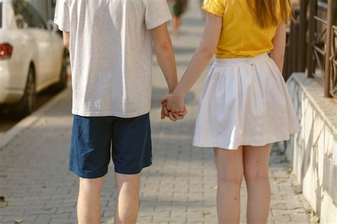 Premium Photo Beautiful Young Couple Walk Hand In Hand On The Road