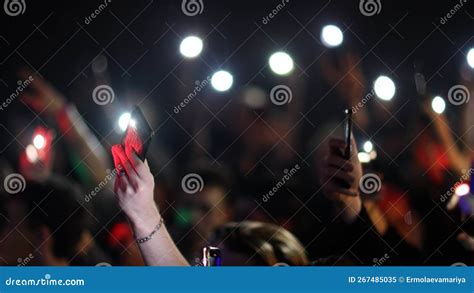 Fans Raise Hands And Takes A Photos In Front Of Bright Colorful