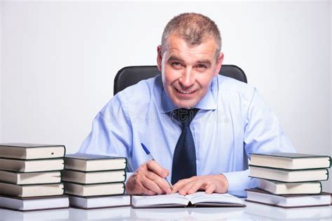 Old Business Man Writes At Desk Full Of Books Stock Photo Image Of