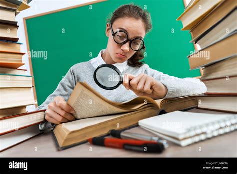 Student With A Magnifying Glass Seeks The Answer In Book Photo Of Girl