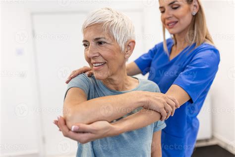 Professional therapists is stretching muscles, senior patient with