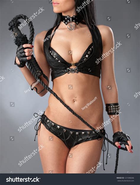 Beautiful Brunette In Leather Black Lingerie Posing With Whip Stock