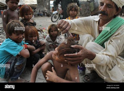 Pakistani children from Lahore's slums wait for their haircuts, in ...