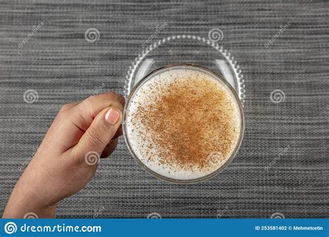 A Woman S Hand Is Holding A White Cup Of Hot Milk Drink With Cinnamon