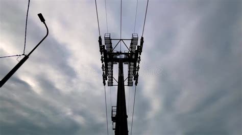 Silhouettes Of Ropeway Cable Car Cabins Are Moving Against Gray Sky In