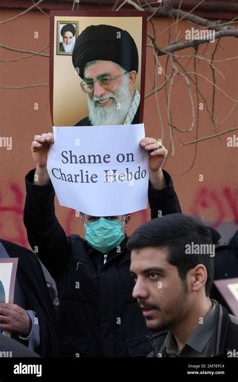 An Iranian Demonstrator Holds Up A Sign And A Poster Showing Portraits Of The Supreme Leader