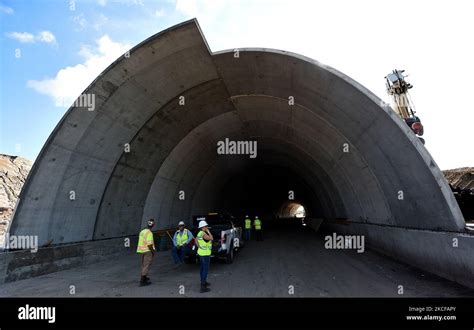 Workers Stand At The Entrance To A Tunnel Under Construction For The 2