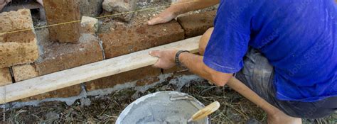 Image of an elderly bricklayer who with a board puts up some tuff ...