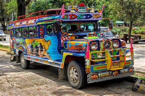 A Colorful Bus Is Parked On The Side Of The Road In Front Of Some Trees