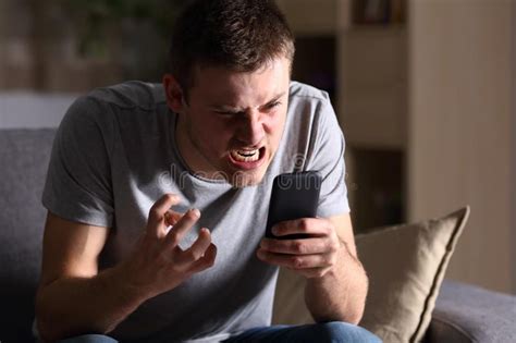 Angry Man With A Mobile Phone At Home Single Angry Person With A