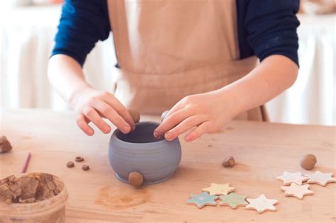 Taller de alfarería para niños niña trabajando con arcilla Foto Premium