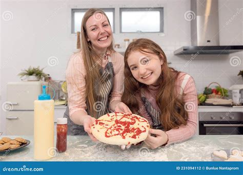 In The Kitchen At Home A Playful Mother And Daughter Yell While Making