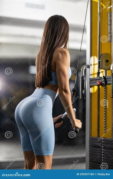 Athletic Fitness Model Pumping Triceps In Crossover Back View Stock