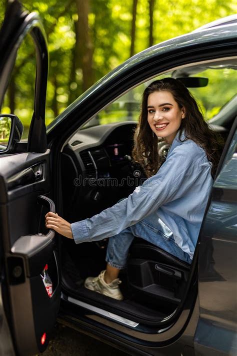 Portrait Of Gorgeous Brunette In Shirt Entering Her Car With One Hand Woman Is Shutting Door