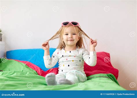 Smiling Little Girl With Sunglasses On Bed At Home Stock Photo Image