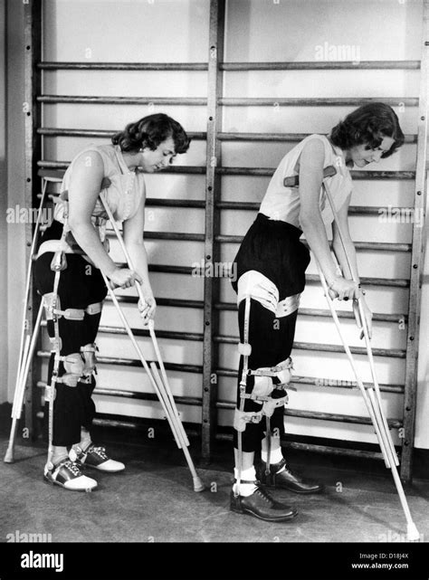 Two Adult Women Polio Victims With Leg Braces Adjust Their Crutches