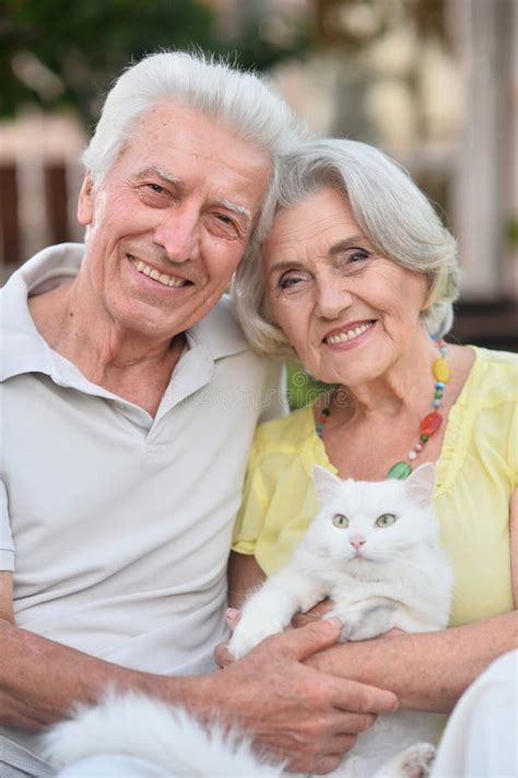 Pareja De Ancianos Sostiene A Un Gato En Sus Brazos En Verano Imagen De