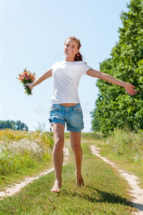 Belle Fille Blonde Marchant Nu pieds Sur Le Champ D été Avec Un Bouquet