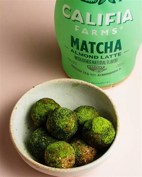Homemade matcha energy balls sit in a bowl at the front of the image