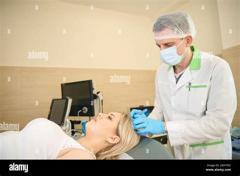 Female Patient Undergoing Surgical Removal Of Sebaceous Cyst On Head