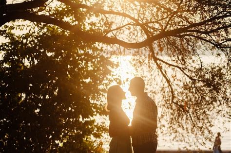 Lindo Casal Relaxa No Parque Junto A Silhueta Da Luz Solar Foto