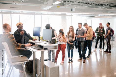 Students Queue At Information Desk In University Library Stock Photo