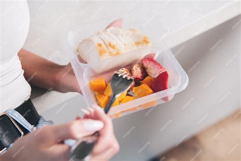 Premium Photo A Person Holding A Plastic Container Of Fruit And