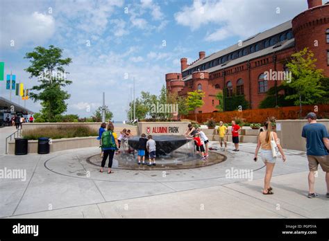 Children And Adults Enjoy The Water Fountain At Alumni Park University