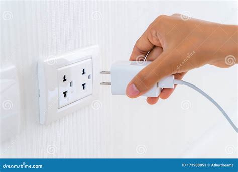 Woman S Hand Inserting Electrical Power Cord Plug Into Receptacle On