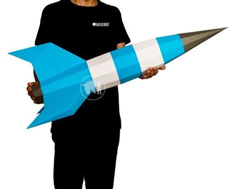 a man holding a blue and white paper rocket