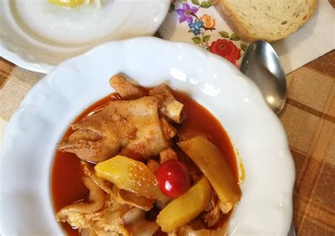 A White Bowl Filled With Food On Top Of A Table Next To Bread And Spoons