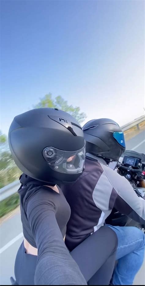 Two People Riding On The Back Of A Motorcycle