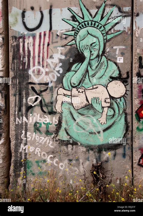 Graffiti Street Art Of Statue Of Liberty Weeping Over The Dead Body Of Famous Palestinian