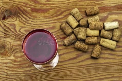 A Glass of Dry Red Wine on a Wooden Surface Next To the Wine Corks in a ...