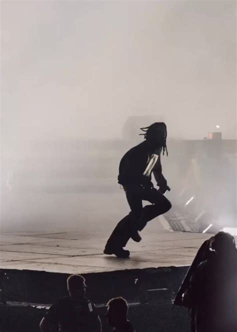 A Man With Dreadlocks Dancing On Stage In Front Of A Group Of People