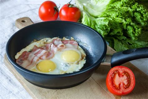 Scrambled Eggs And Bacon On Frying Pan On Table Close Up Stock Photo