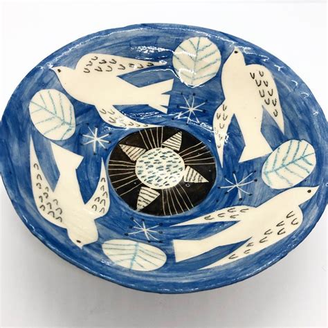 A Blue And White Bowl With Birds Painted On The Side In Different