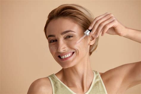 Woman Applying Serum On Face Woman Applying Essential Oil On Facial