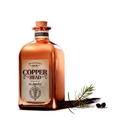 A Bottle Of Copper Colored Liquid Sitting On Top Of A White Surface