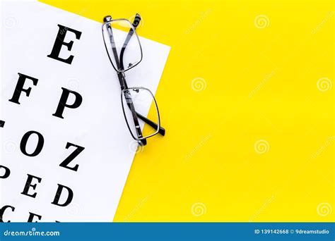 Eye Examination Eyesight Test Chart And Glasses On Yellow Background