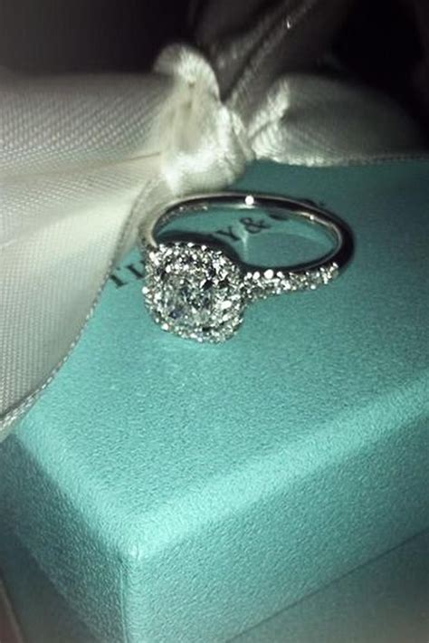 A Diamond Engagement Ring Sitting On Top Of A Blue Box With A White