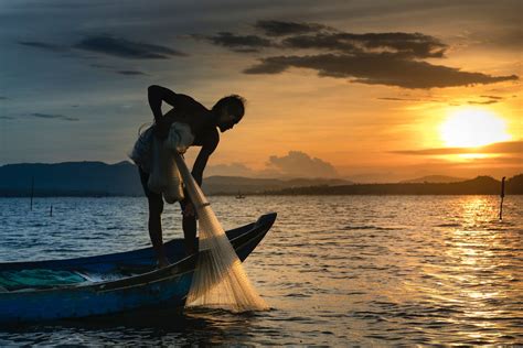 Man on Boat Holding White Mesh Fishing Net · Free Stock Photo