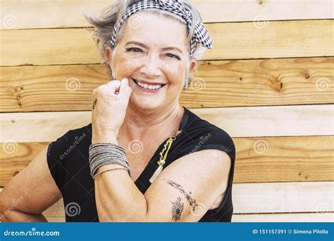 Une Femme Caucasienne âgée Et Joyeuse Montre Son Tatouage Sur Le Bras