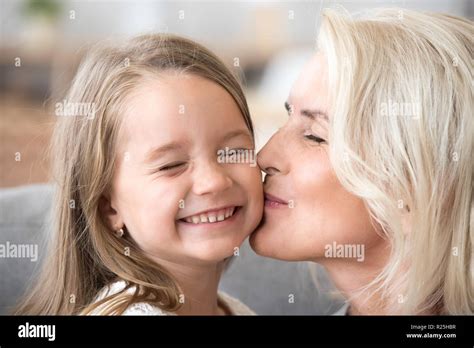 Loving Old Grandmother Kissing Cute Preschool Granddaughter On C Stock