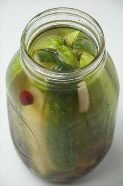 A Glass Jar Filled With Green Liquid And Fruit