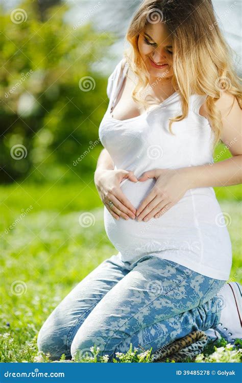 Portrait D Une Femme Enceinte S Asseyant Sur L Herbe Photo Stock