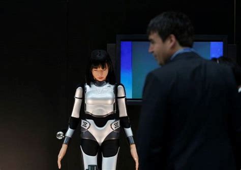 Un hombre examina el robot humanoide HRP 4C Miim en la reunión anual