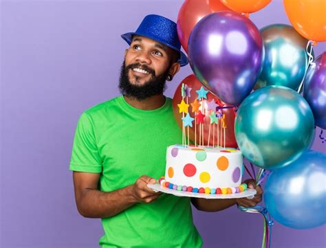 Sonriente Joven Afroamericano Vistiendo Gorro De Fiesta Sosteniendo