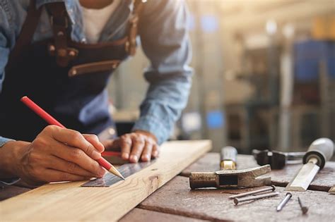 Carpinteiro que trabalha em máquinas do woodworking na loja da